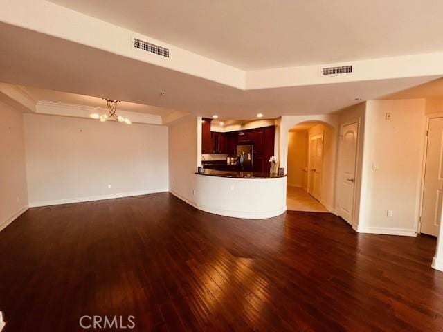 14242 Burbank Blvd Unit 103, Sherman Oaks, CA 91401 - unfurnished living room featuring arched walkways, a raised ceiling, and dark wood finished floors