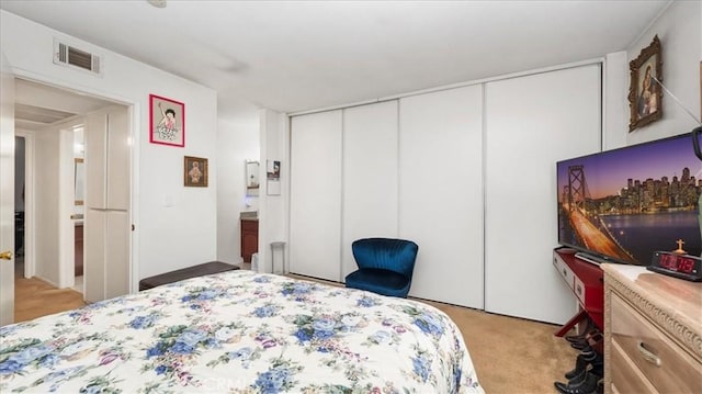 bedroom with visible vents, a closet, and light colored carpet