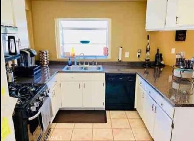 kitchen featuring light tile patterned floors, dishwasher, gas range, white cabinetry, and a sink