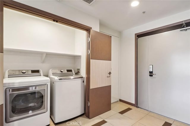 laundry room featuring laundry area, visible vents, washer and clothes dryer, and light tile patterned floors