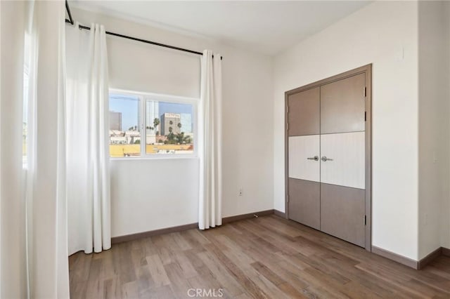 unfurnished bedroom featuring light wood-style flooring and baseboards