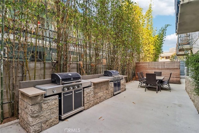 view of patio / terrace featuring grilling area, outdoor dining area, area for grilling, and a fenced backyard