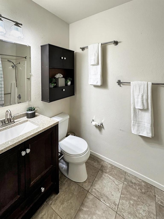 full bathroom featuring toilet, vanity, tile patterned flooring, baseboards, and walk in shower