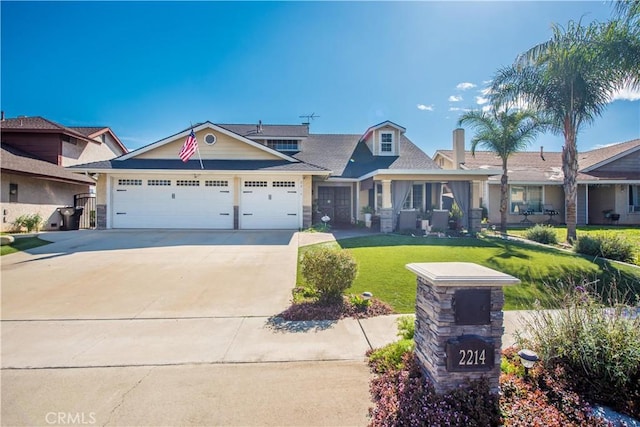 view of front of home with driveway, an attached garage, and a front lawn