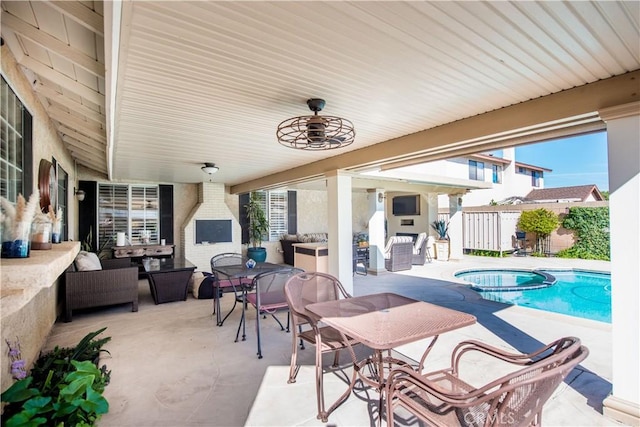 view of patio featuring an outdoor living space with a fireplace, fence, a pool with connected hot tub, and a ceiling fan