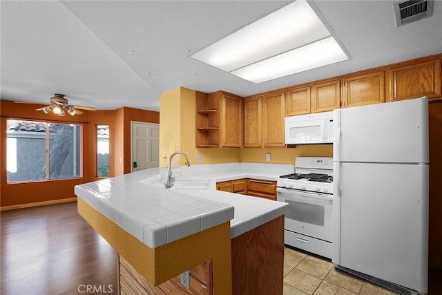 kitchen featuring visible vents, tile countertops, a peninsula, white appliances, and open shelves