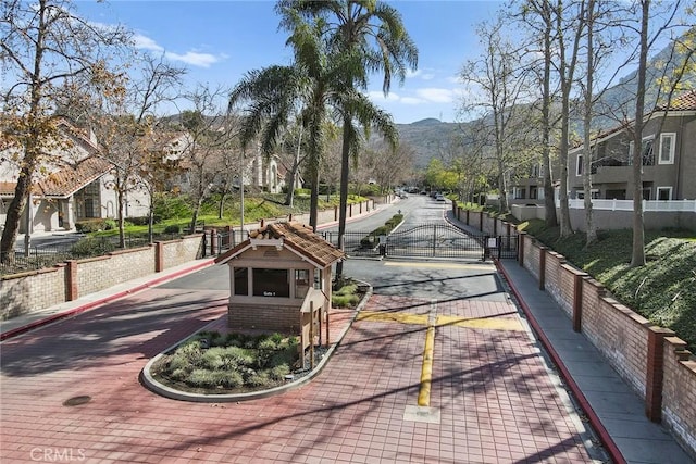view of community featuring fence, a mountain view, and a residential view