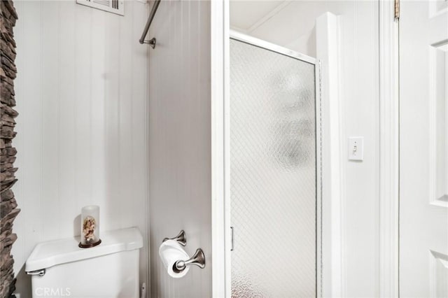 full bathroom with toilet, a stall shower, and visible vents