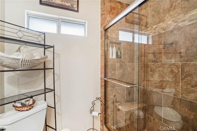 full bathroom featuring a shower stall and toilet