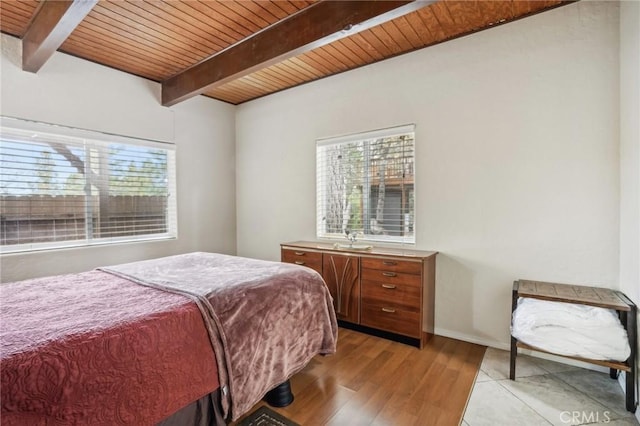 bedroom featuring wood ceiling, beamed ceiling, and light wood finished floors