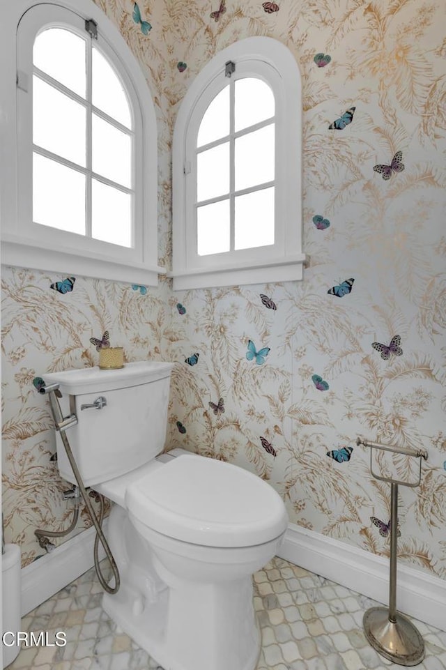 bathroom with baseboards, tile patterned floors, toilet, and wallpapered walls