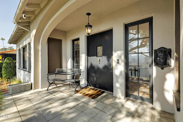 property entrance featuring a patio and stucco siding