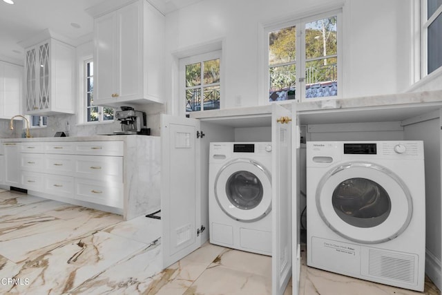 washroom featuring marble finish floor, washer and clothes dryer, and a sink