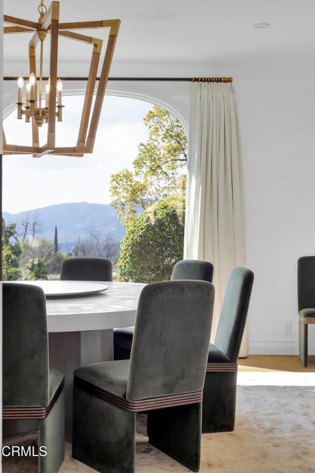 dining space with a mountain view and an inviting chandelier