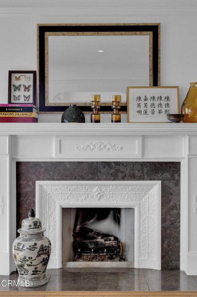 details with ornamental molding and a tile fireplace