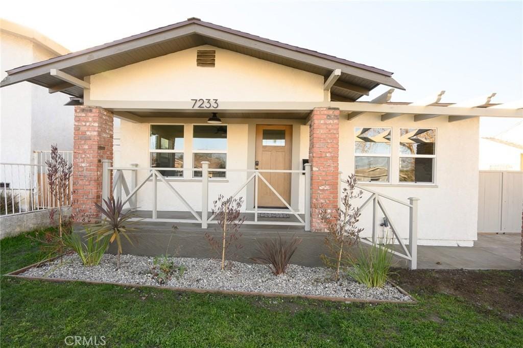 view of exterior entry featuring fence and stucco siding