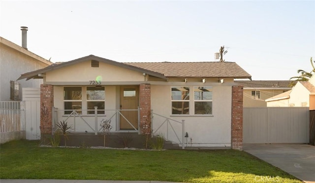 view of front of house featuring a front yard, driveway, fence, and stucco siding