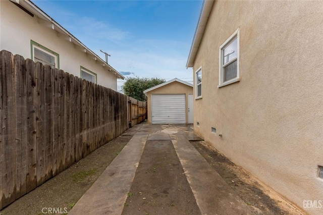 view of property exterior featuring crawl space, an outdoor structure, fence, and stucco siding