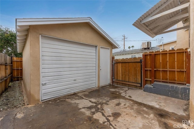 detached garage with a gate and fence