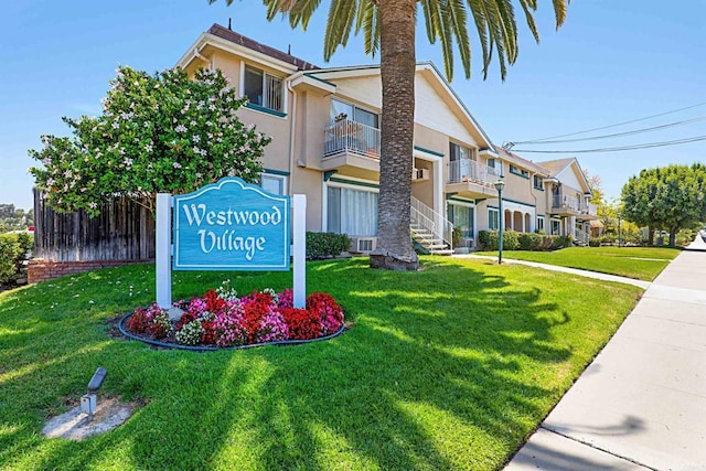 community / neighborhood sign featuring a residential view and a lawn