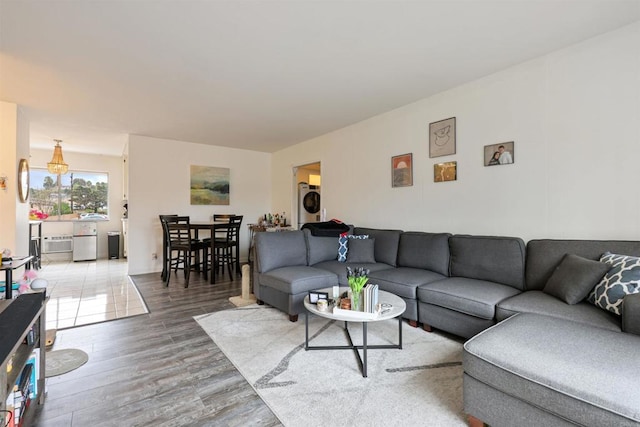 living room featuring stacked washing maching and dryer and wood finished floors