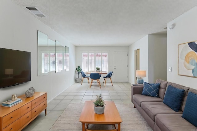 living room featuring light tile patterned flooring and visible vents