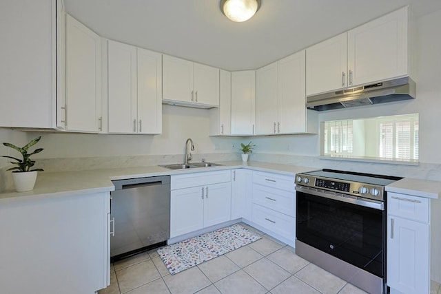 kitchen with stainless steel appliances, light countertops, white cabinets, a sink, and under cabinet range hood