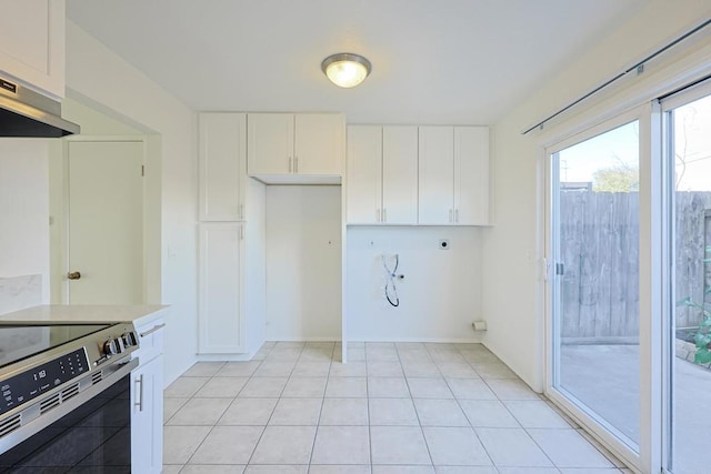 kitchen featuring light countertops, electric range, white cabinets, light tile patterned flooring, and under cabinet range hood