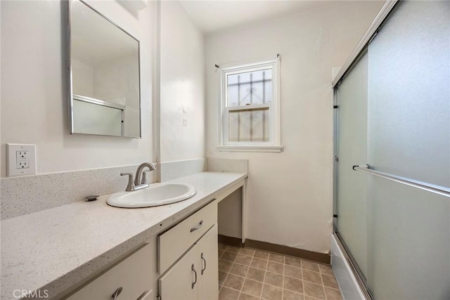 bathroom with shower / bath combination with glass door, vanity, and baseboards