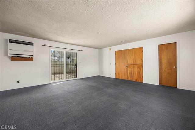 unfurnished room featuring baseboards, dark colored carpet, and a textured ceiling