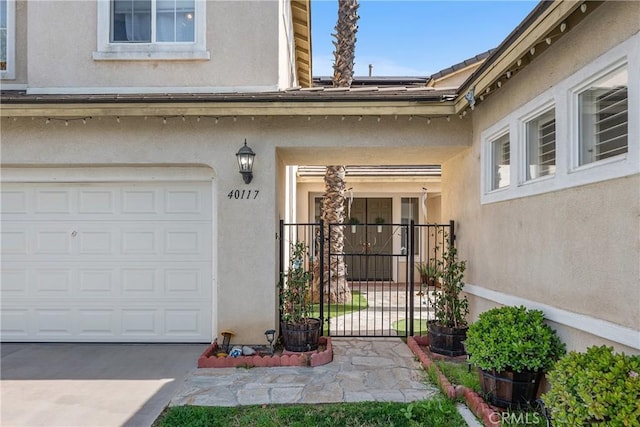 property entrance featuring a garage and stucco siding