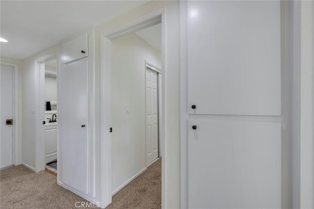 corridor featuring light colored carpet