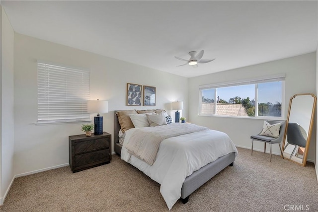 carpeted bedroom with ceiling fan and baseboards