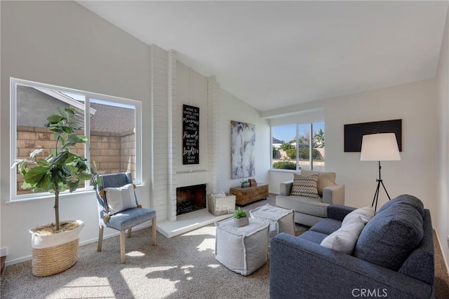 carpeted living area featuring vaulted ceiling, a fireplace, and baseboards