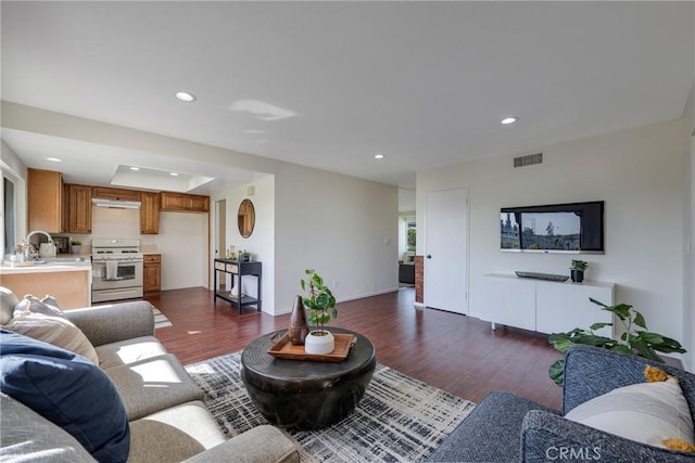 living room featuring dark wood-style floors, recessed lighting, and visible vents