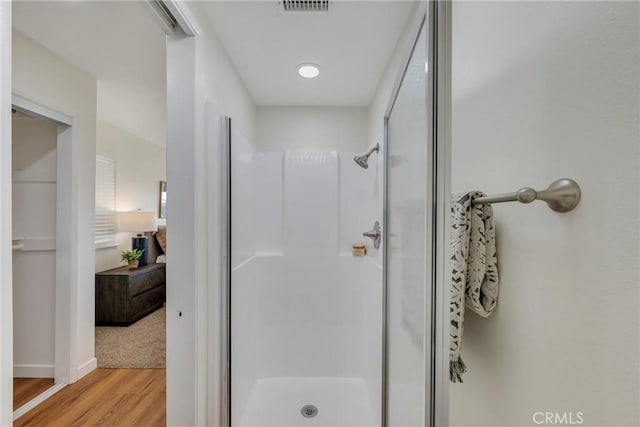 full bathroom featuring a stall shower and wood finished floors