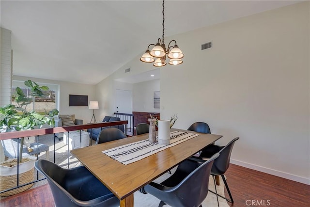 dining room with visible vents, vaulted ceiling, baseboards, and wood finished floors