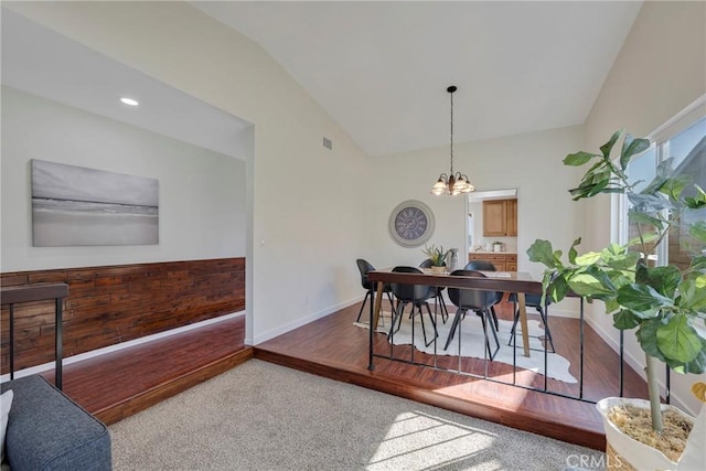 dining area with vaulted ceiling, baseboards, visible vents, and an inviting chandelier