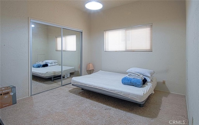 bedroom with a closet, carpet flooring, and a textured wall