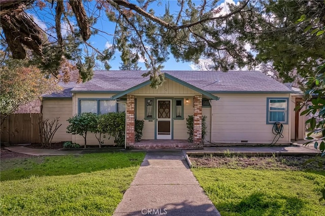 view of front of home featuring a front yard, brick siding, and fence