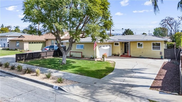 ranch-style home with driveway, an attached garage, fence, a front lawn, and stucco siding