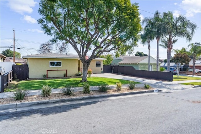 single story home with fence private yard, driveway, a front lawn, and stucco siding