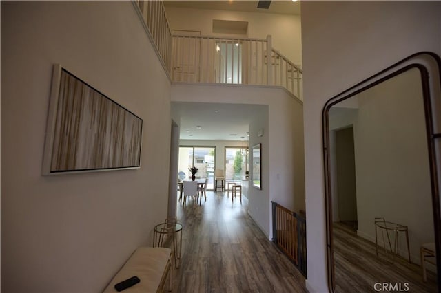 hallway with dark wood-type flooring and a high ceiling