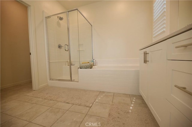 bathroom with a stall shower, tile patterned flooring, and a bath