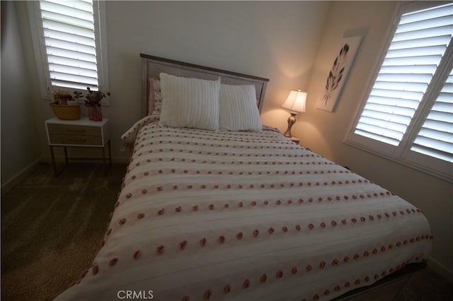 bedroom with multiple windows and dark carpet