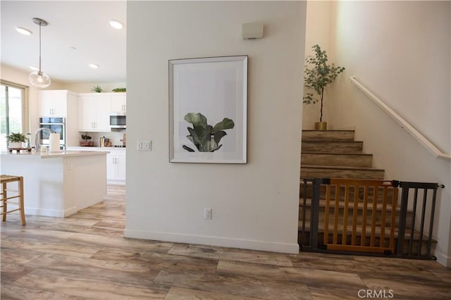 stairs featuring recessed lighting, wood finished floors, and baseboards