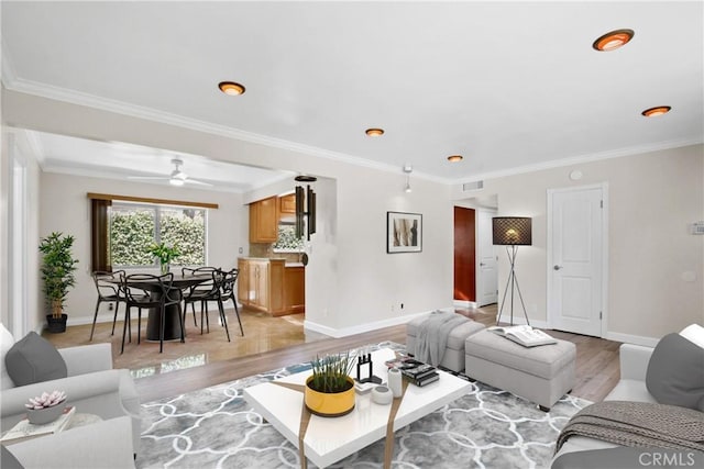 living area featuring baseboards, ornamental molding, visible vents, and light wood-style floors