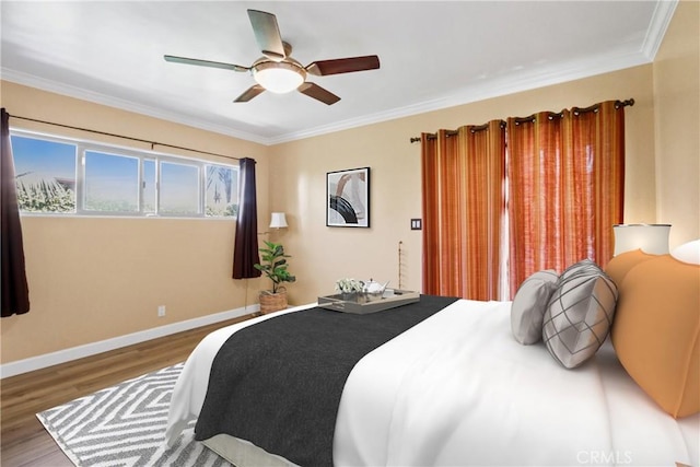 bedroom featuring ceiling fan, ornamental molding, wood finished floors, and baseboards