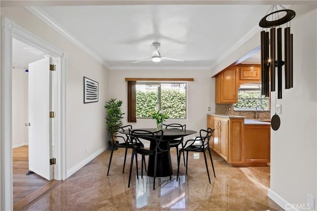 dining space featuring ceiling fan, baseboards, and crown molding