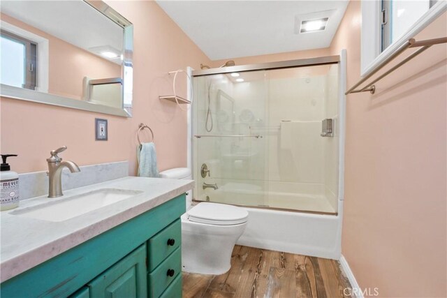 full bathroom featuring toilet, enclosed tub / shower combo, wood finished floors, and vanity